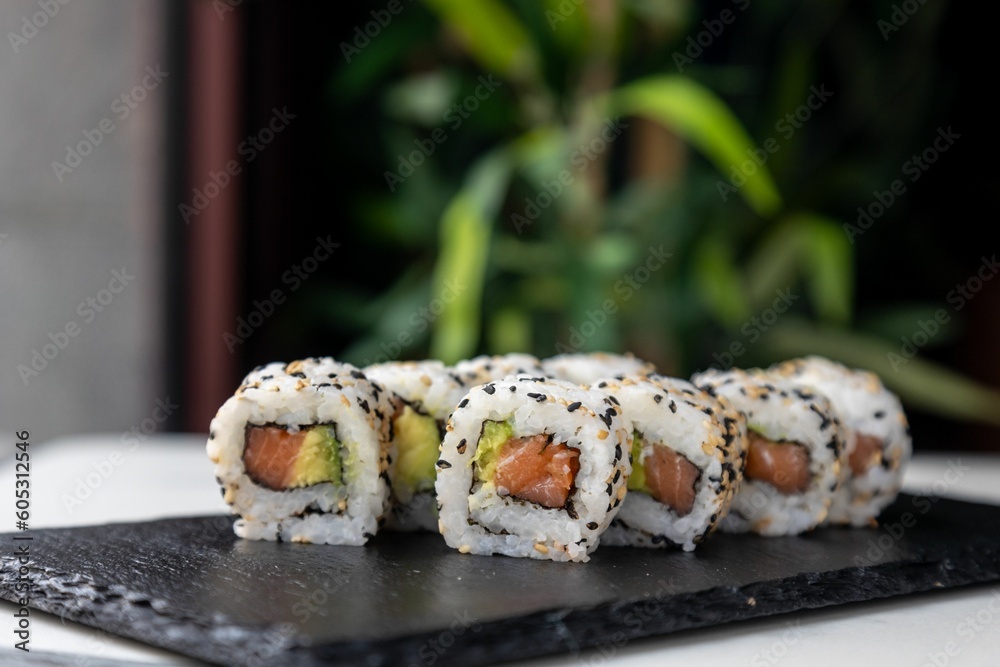 Closeup of Asian sushi rolls on black kitchen board Closeup of Asian sushi rolls on black kitchen board