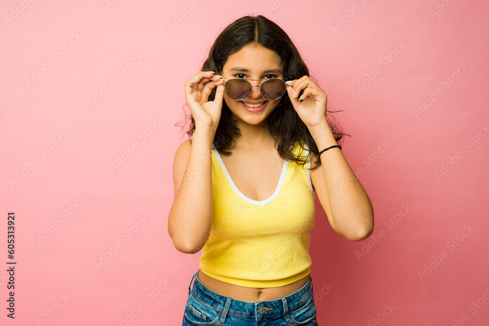 Adorable teenager putting on summer sunglasses Adorable teenager putting on summer sunglasses
