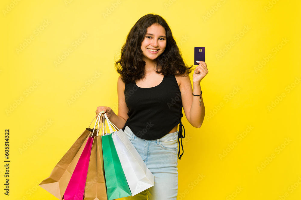 Teen girl buying shopping bags with a credit card Teen girl buying shopping bags with a credit card