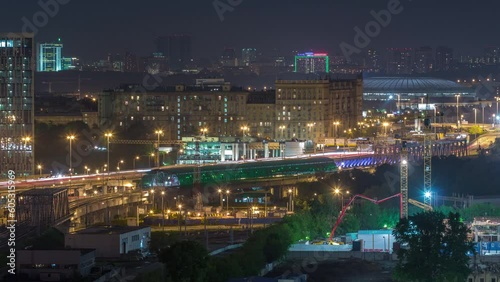 Moscow timelapse panorama, night aerial top view of the third transport ring and the central part of Moscow's rings, traffic, car lights from rooftop. Luzhniki stadium on background