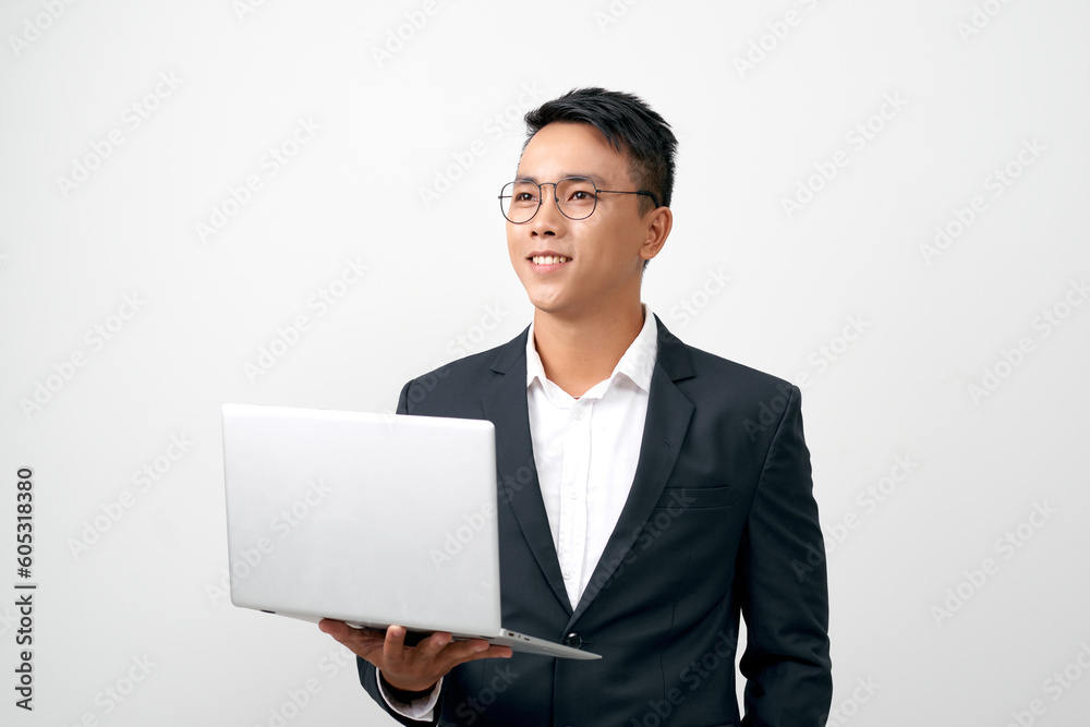 Smiling young man standing in black suit and glasses, holding open laptop, Smiling young man standing in black suit and glasses, holding open laptop,