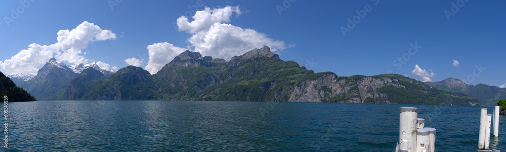 Wide angle mountain panorama with Lake Uri in the foreground on a sunny spring day. Photo taken May 22nd, 2023, Sisikon, Switzerland. Wide angle mountain panorama with Lake Uri in the foreground on a sunny spring day. Photo taken May 22nd, 2023, Sisikon, Switzerland.