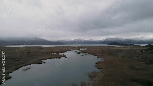 Panoramic Aerial View: Misty Mountains and Lake Prespa, Macedonia, Greece - Creek Flyover (ID: 605320597)