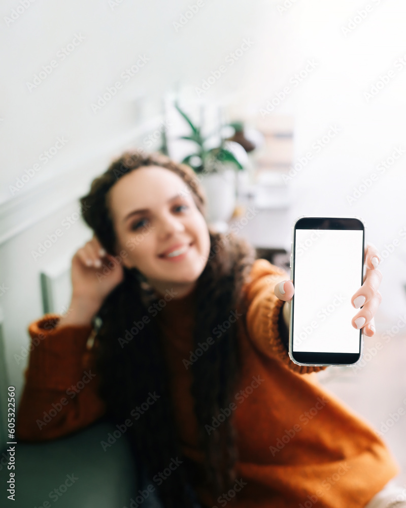 Happy young woman holding mobile phone in hand showing cellphone display, presenting big white blank cellular display template mock up, smartphone mockup screen for digital application promo ads. Happy young woman holding mobile phone in hand showing cellphone display, presenting big white blank cellular display template mock up, smartphone mockup screen for digital application promo ads.