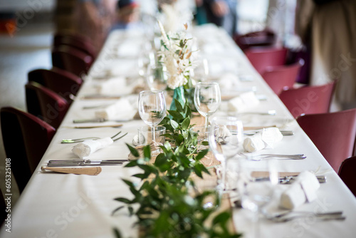 Une table de mariage moderne avec des décorations, des couverts, des fleurs séchés et de napperons blanc