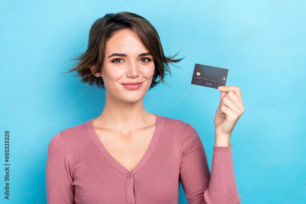 Photo of cheerful positive lady wear pink cardigan smiling rising bank card isolated blue color background Photo of cheerful positive lady wear pink cardigan smiling rising bank card isolated blue color background