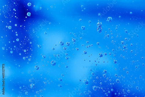 Water drops on blue background. Abstract water bubbles on glass over green.