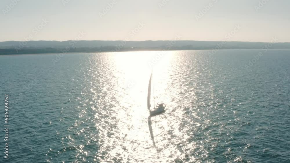 Aerial View of Sunset and Sea with Sailboat While Cruising and Sailing in the Sea. Yacht With Full Sail Up at the end of a Windy Day. Sailing Theme - Background. Lantern Design for Yachting. Aerial View of Sunset and Sea with Sailboat While Cruising and Sailing in the Sea. Yacht With Full Sail Up at the end of a Windy Day. Sailing Theme - Background. Lantern Design for Yachting.
