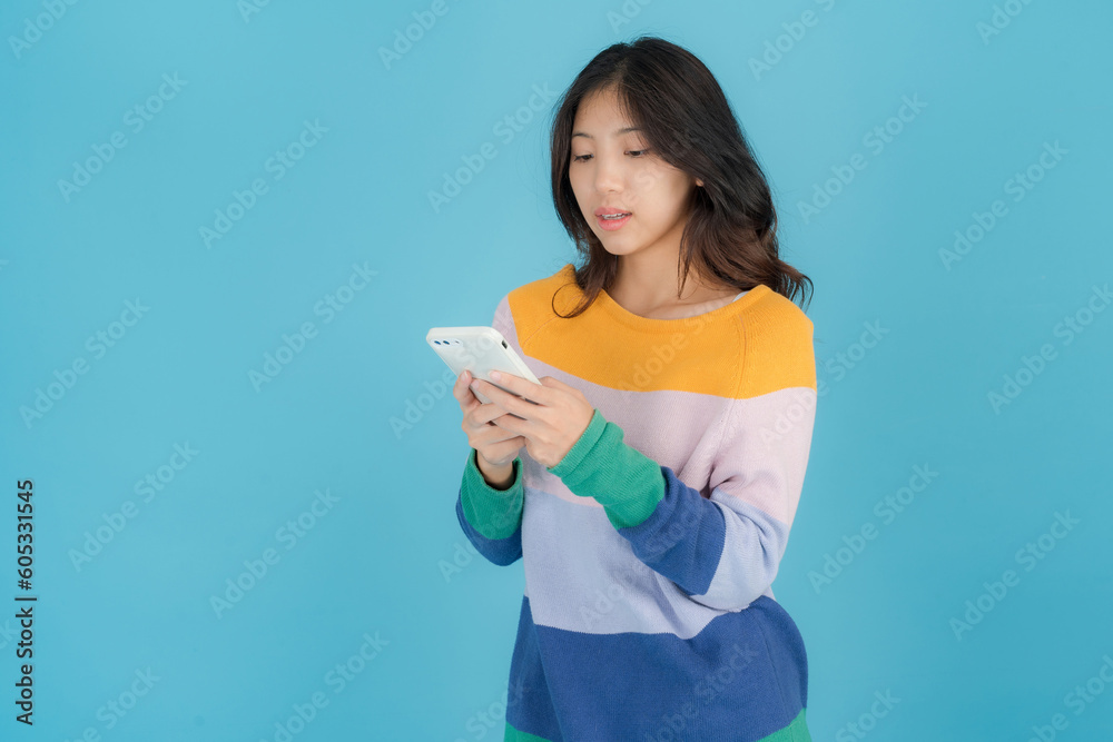 Beautiful young woman smiling happily while holding a Smartphone in her hand Beautiful young woman smiling happily while holding a Smartphone in her hand