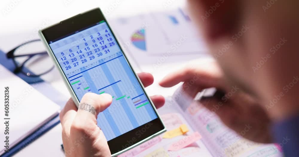 Businessman Holding Cellphone And Calendar Writing Schedule Businessman Holding Cellphone And Calendar Writing Schedule