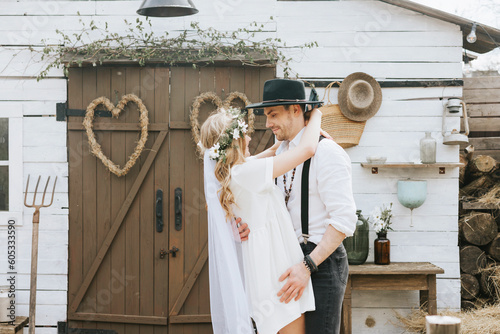 Obraz na plátně young couple newlyweds bride in short white dress and wreath with veil and groom