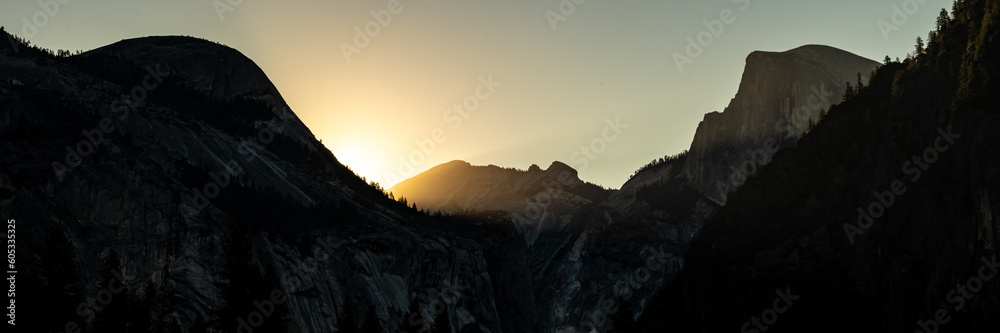Silhouettes Of North Dome And Half Dome As Sun Rises Over The Ridge Behind Them