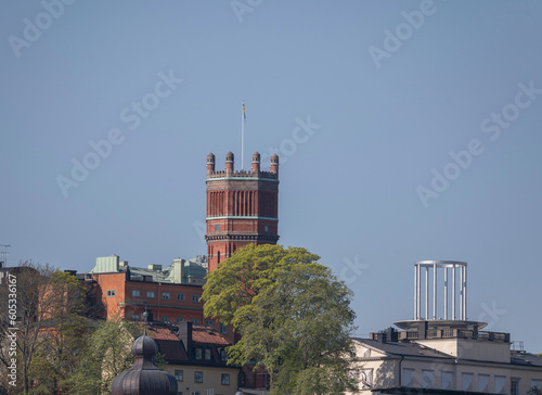 Old water brick tower and the roof of the tower Söder Torn in the district Södermalm, a tranquil sunny summer day in Stockholm