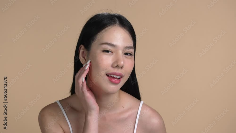 Attractive young Asian woman posing at beige background Attractive young Asian woman posing at beige background