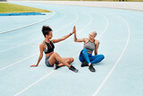 Woman, team and high five on stadium track for running, workout or exercise together for goal outdoors. Sports women touching hands for support, fitness or friends in motivation, teamwork or training
