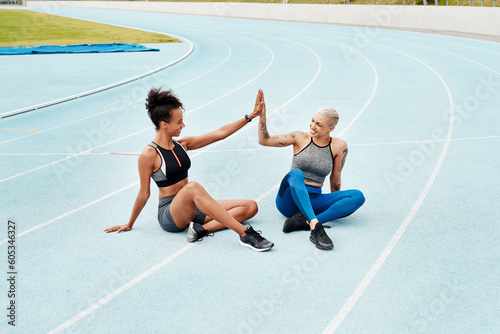 Woman, team and high five on stadium track for running, workout or exercise together for goal outdoors. Sports women touching hands for support, fitness or friends in motivation, teamwork or training