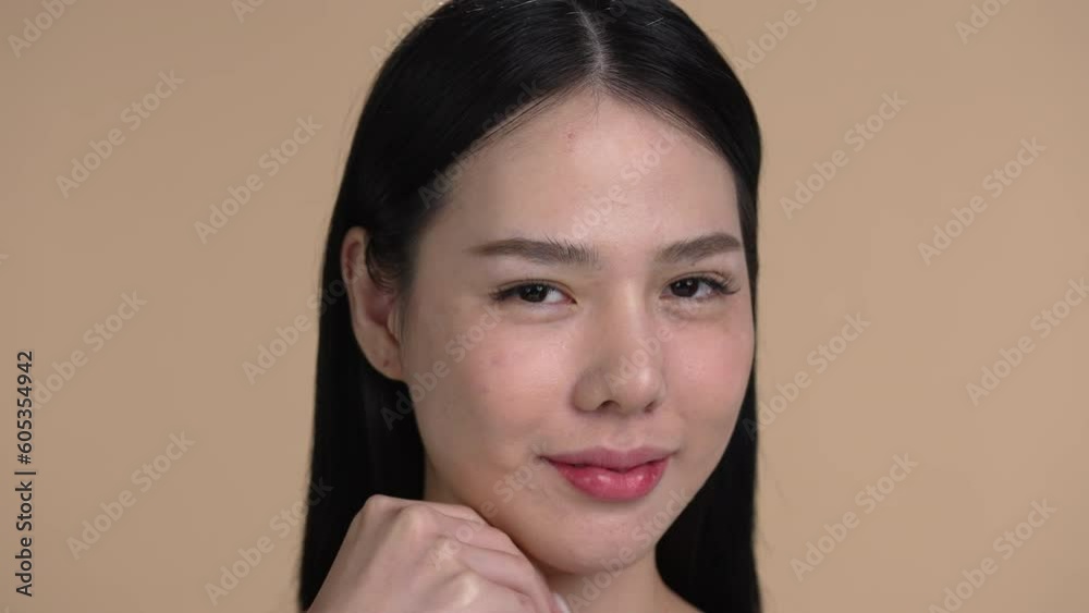 Attractive young Asian woman posing at beige background Attractive young Asian woman posing at beige background