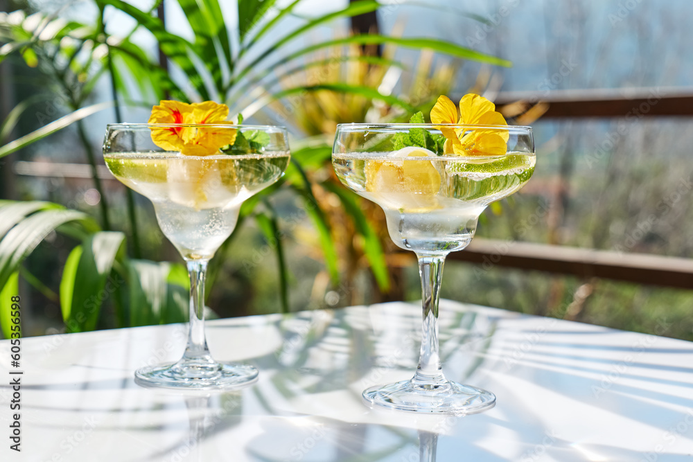 Iced lemonade with edible nasturtium flowers, lime and mint leaves. Refreshing summer drink. Healthy organic summer soda drink. Detox water. Diet unalcolic coctail.