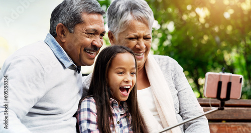 Laugh, grandparents and young girl take selfie at the park or senior woman or man and excited for picture with kid. Family, child and happy for photo with elderly or spring and bench outside