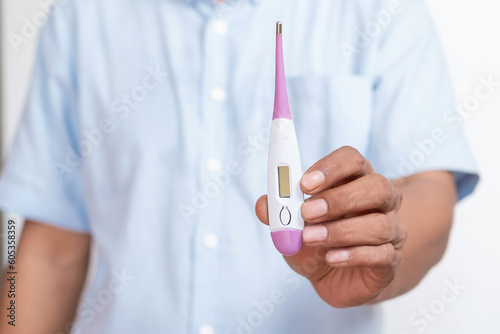 Doctor's hand holding a digital thermometer.