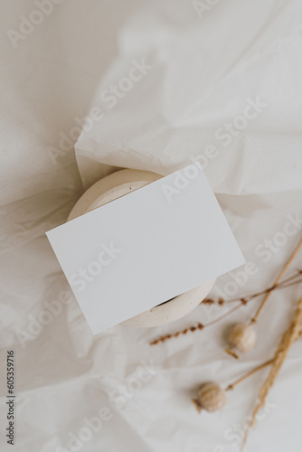 Blank paper card sheet with empty free copy space for mock up. Dried grass, poppy stems and clay pot. Aesthetic neutral beige colour. Flat lay, top view