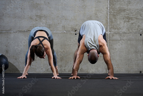 An attractive couple in the gym engaging in various stretching exercises together, showcasing their dedication to fitness, flexibility, and overall well-being. With synchronized movements, they