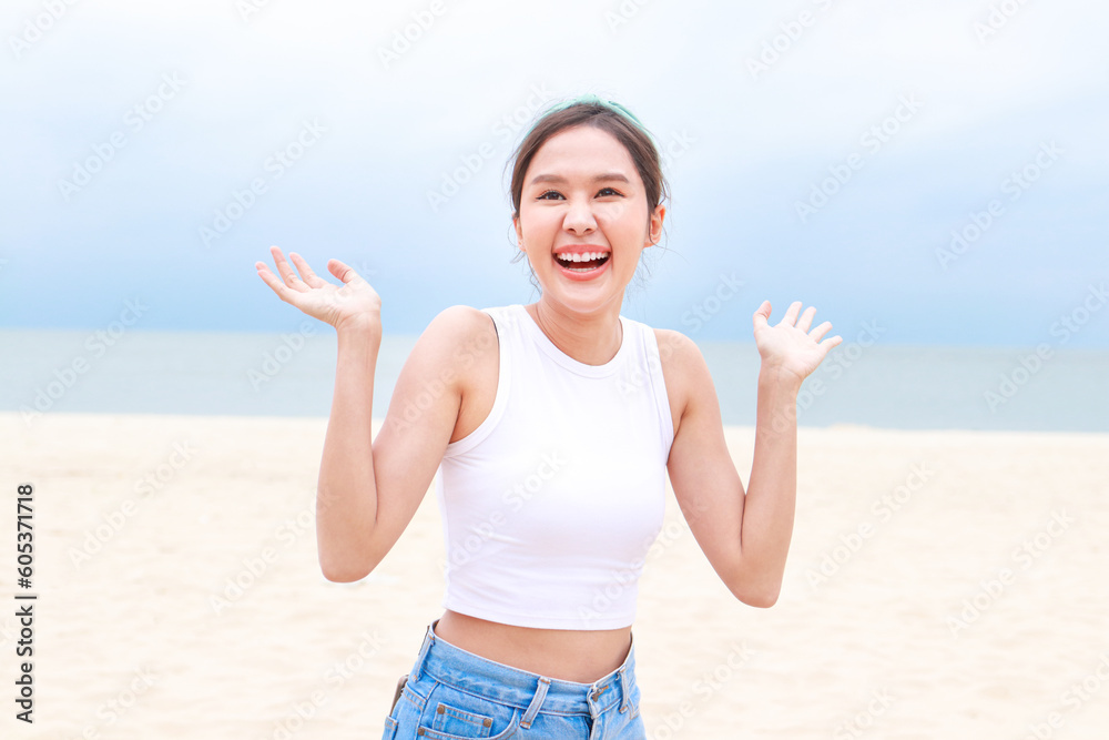 Portrait of a beautiful young Asian woman, cheerful, having fun. Smiling, happy to travel to the sea on weekends. Standing on a beautiful clean beach. travel concept Portrait of a beautiful young Asian woman, cheerful, having fun. Smiling, happy to travel to the sea on weekends. Standing on a beautiful clean beach. travel concept