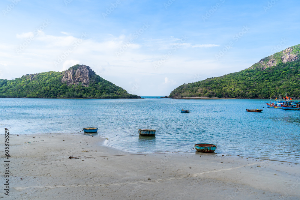Obraz premium Ben Dam Port in Con Dao island, Vietnam with beautiful blue sea blue sky mountain and colorful boats.