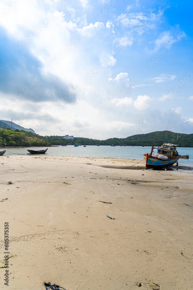Fototapeta premium Ben Dam Port in Con Dao island, Vietnam with beautiful blue sea blue sky mountain and colorful boats.