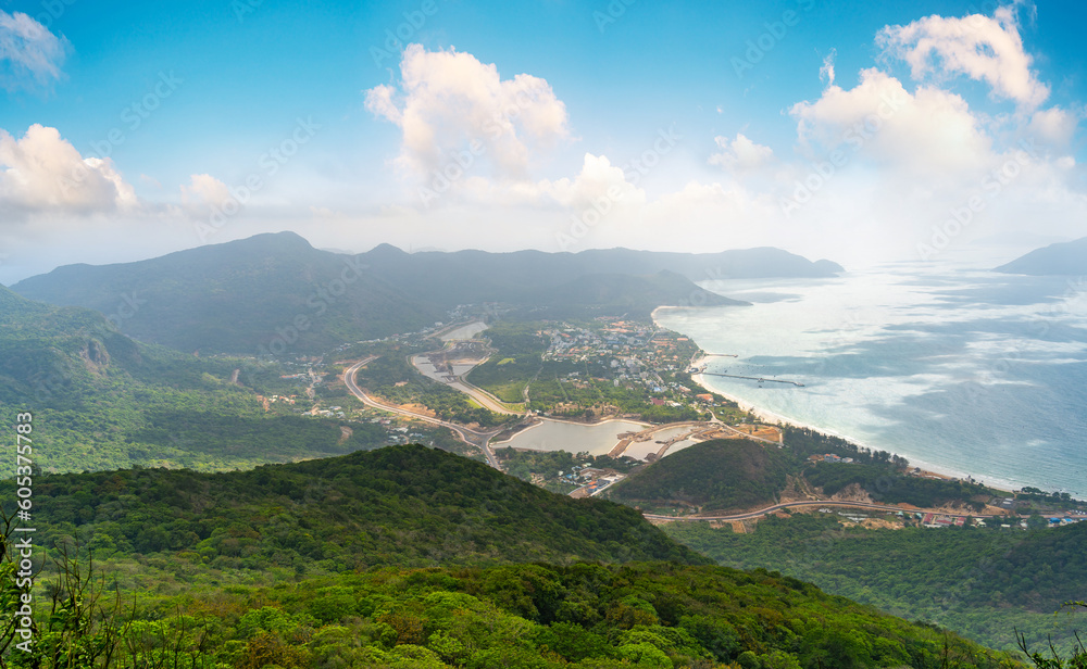 Fototapeta premium a peaceful Con Dao island, Vietnam, view from Thanh Gia mountain. Coastal view with waves, coastline, clear sky and road, blue sea and mountain.