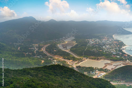 a peaceful Con Dao island, Vietnam, view from Thanh Gia mountain. Coastal view with waves, coastline, clear sky and road, blue sea and mountain.