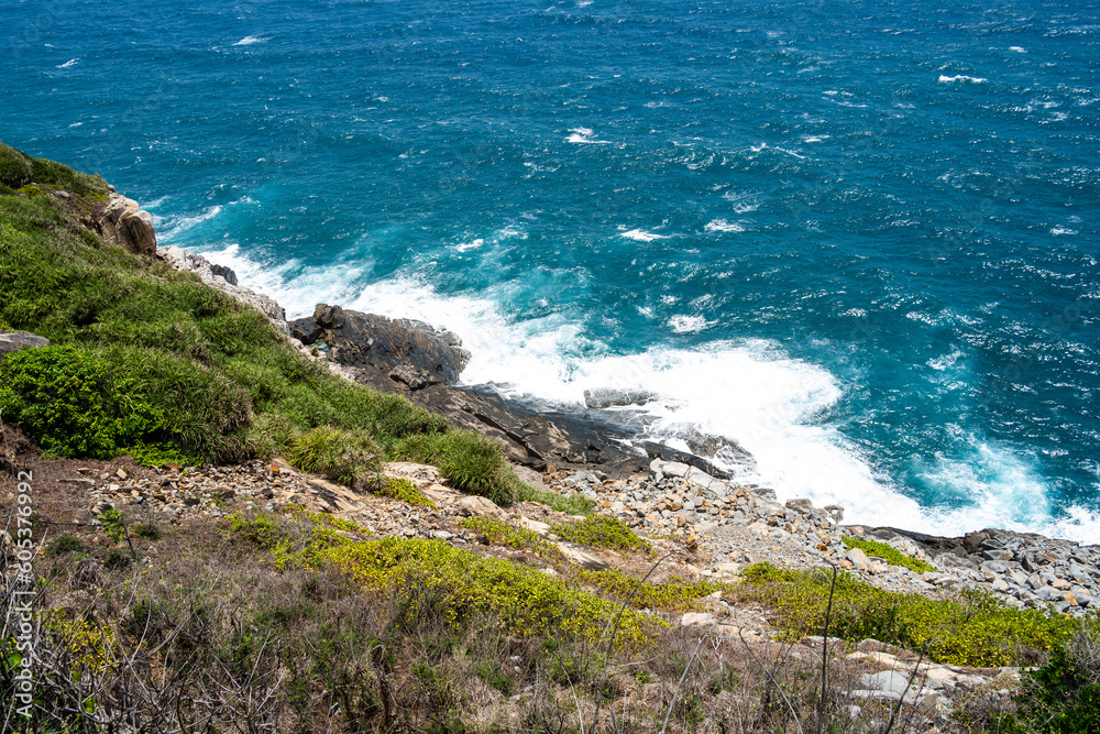 Fototapeta premium a peaceful Con Dao island, Vietnam is a Vietnamese island heaven. Coastal view with waves, coastline, clear sky and road, blue sea, tourists and mountain