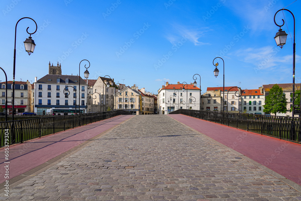 Symmetric view of the cobbled street on the market bridge spanning the Marne river in the city center of Meaux in Seine et Marne near Paris, France