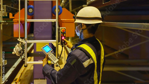 Фотография A mechanic is testing the machine after finishing installation in an industrial factory