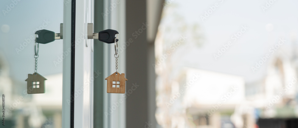 Landlord key for unlocking house is plugged into the door. Second hand house for rent and sale. keychain is blowing in the wind. mortgage for new home, buy, sell, renovate, investment, owner, estate