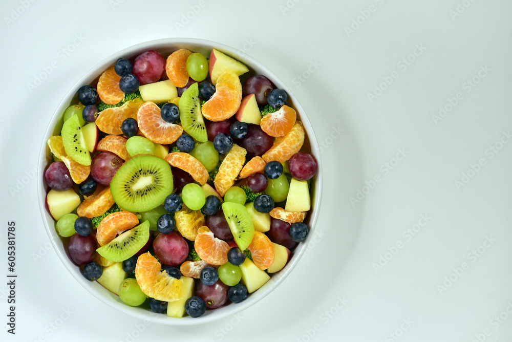 Healthy fresh fruit salad bowl on white background. Top view. Healthy food concept, healthy high vitamin fruit, mixed fruit background. Healthy fresh fruit salad bowl on white background. Top view. Healthy food concept, healthy high vitamin fruit, mixed fruit background.