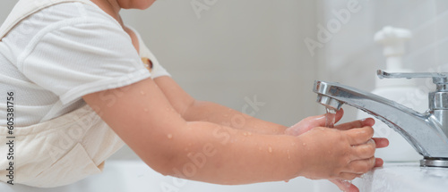 little kid hands wash with soap bubbles and rinse with clean water to prevent and stop the spread of germs after back to home, virus or covid19. Good health and good personal hygiene, virus, bacteria