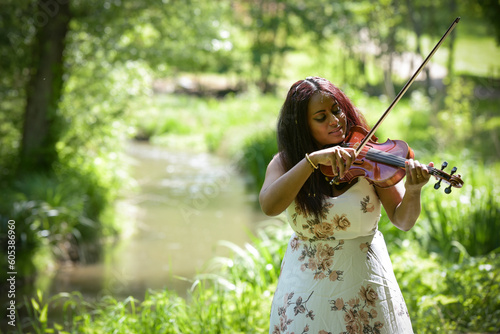 young woman playing the violin in a park in France