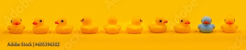 Foto Yellow rubber ducks and one turquoise in a row