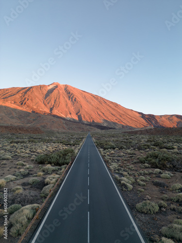 Long straight street leading to a huge vulcano lightened by the sunset