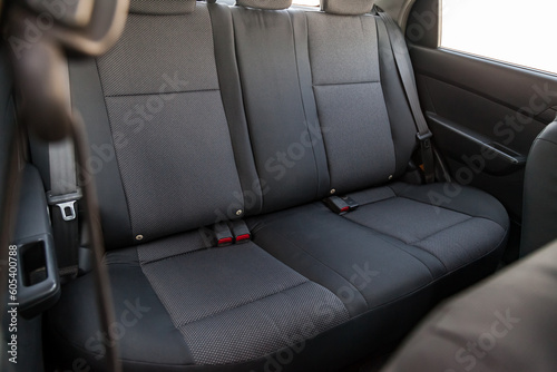 Close-up on rear seats with velours fabric upholstery in the interior of an old Korean car in gray after dry cleaning. Auto service industry. © Aleksandr Kondratov