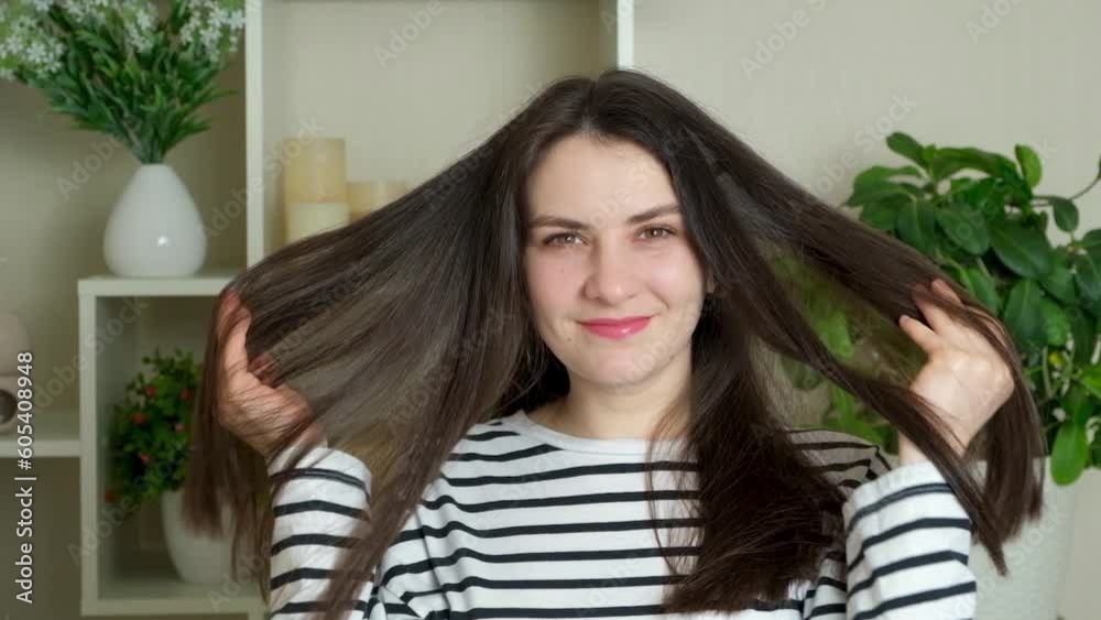 Happy brunette woman with long straight hair turns to the camera and smiles Happy brunette woman with long straight hair turns to the camera and smiles