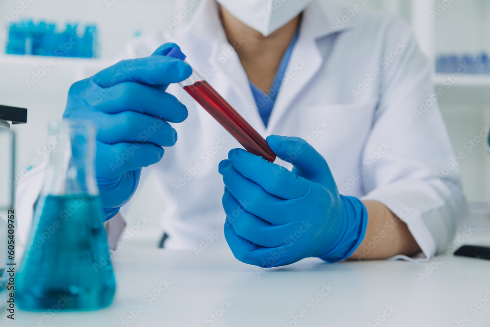 medical or scientific researcher researching and experimenting Multi-colored solution, vial and microscope In the laboratory or in the laboratory by wearing blue gloves and white clothing completely. medical or scientific researcher researching and experimenting Multi-colored solution, vial and microscope In the laboratory or in the laboratory by wearing blue gloves and white clothing completely.