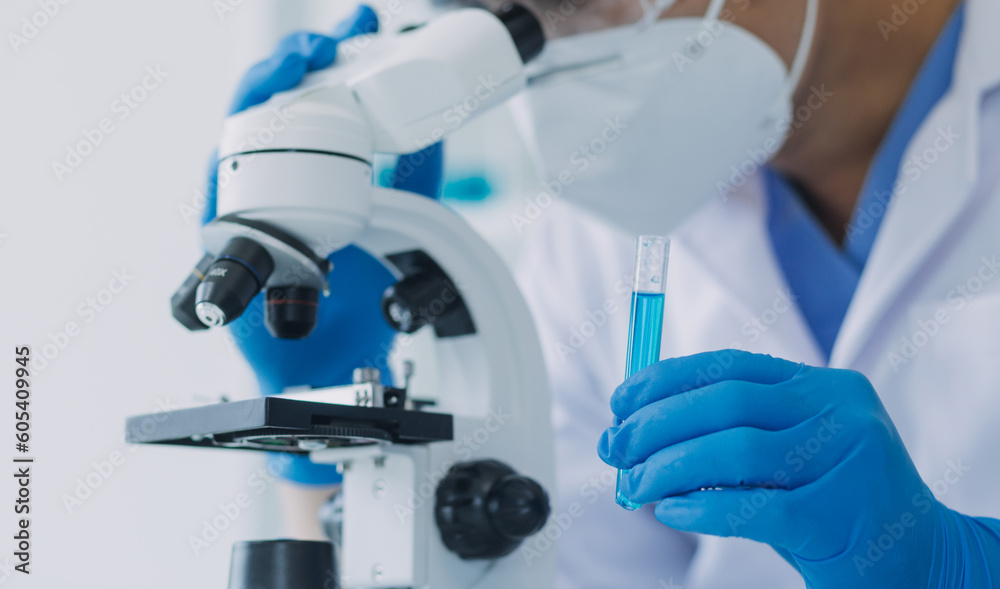 medical or scientific researcher researching and experimenting Multi-colored solution, vial and microscope In the laboratory or in the laboratory by wearing blue gloves and white clothing completely. medical or scientific researcher researching and experimenting Multi-colored solution, vial and microscope In the laboratory or in the laboratory by wearing blue gloves and white clothing completely.