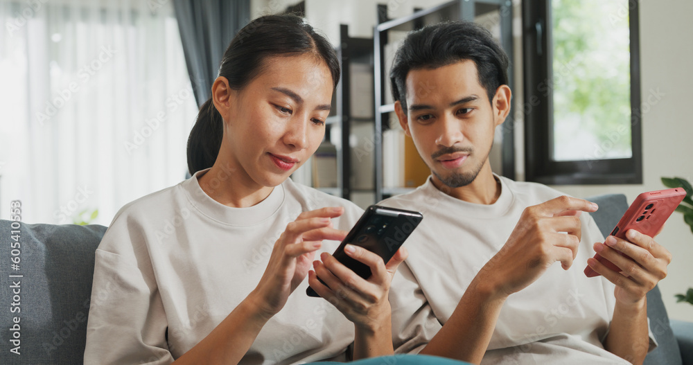 Ταπετσαρία Young Asian couple sit on couch spend time together have fun use smartphone devices online shopping at home