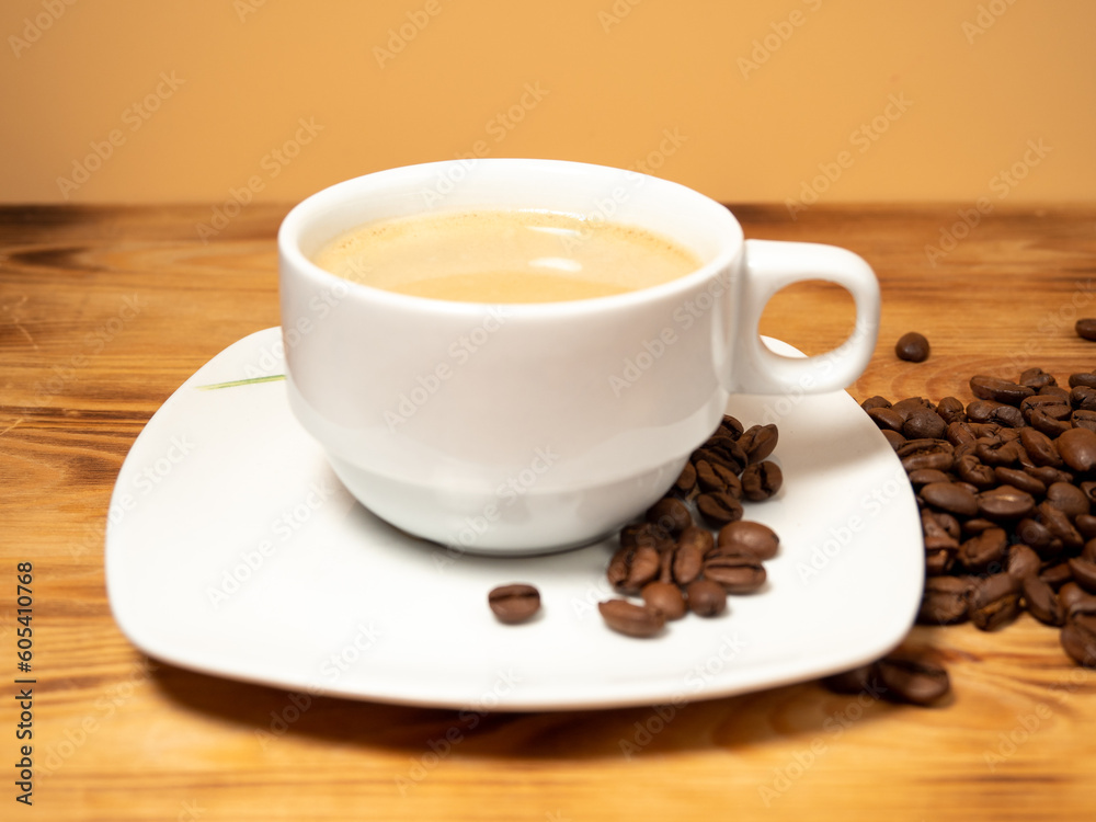 Cup of coffee and roasted coffee beans on a wooden background. Cup of coffee closeup. Cup of coffee and roasted coffee beans on a wooden background. Cup of coffee closeup.