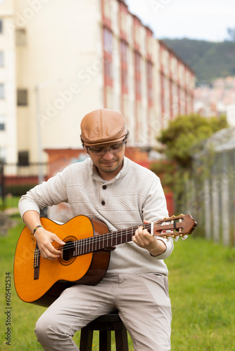 musician composing music outdoors with hat and glasses