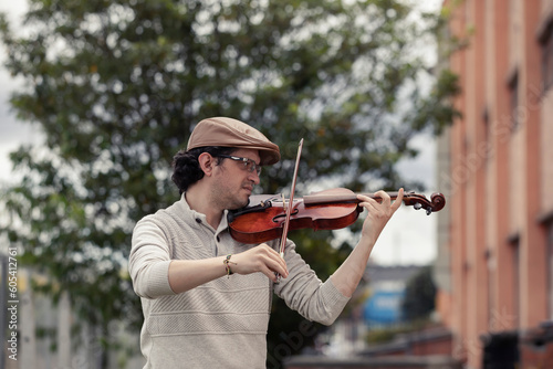 man composing music in the park playing a violin