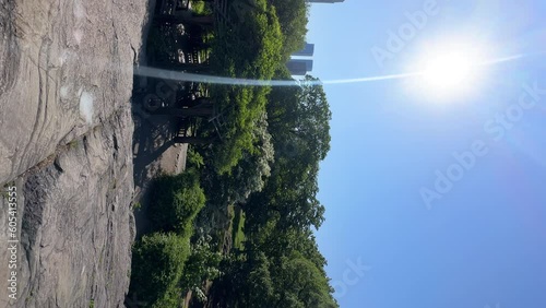 Vertica panoramicl view of the Central Pak in Manhattan, New York city. View of green trees and high skyscrapers seen behind them. Bright sunny day with sunshine and he blue sky.  photo