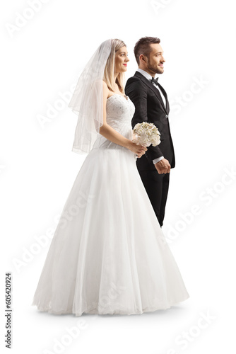 Full length profile shot of a bride and groom standing next to each other